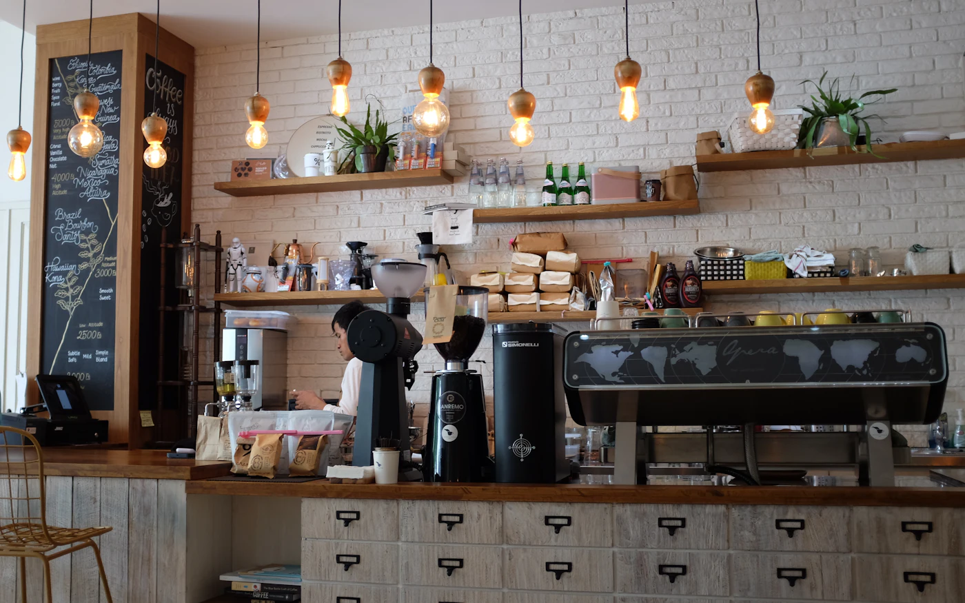 Coffee shop counter with an espresso machine and hanging lights