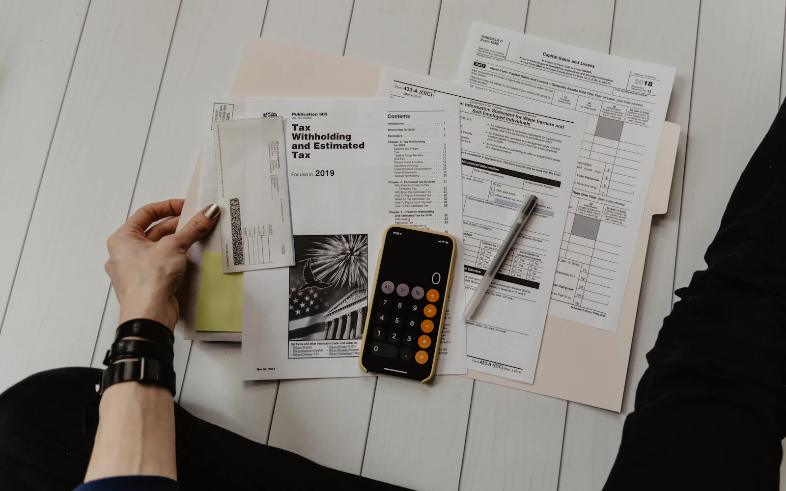 Person checking bills and statements with a calculator on a table
