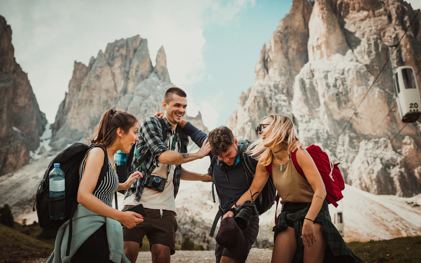 Group of hikers with backpacks in front of mountain peaks