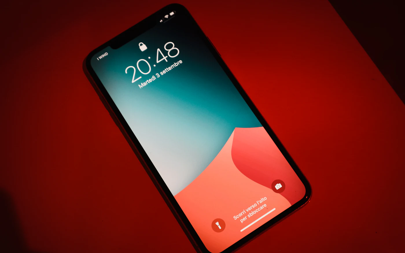 iPhone lying face up on a red table