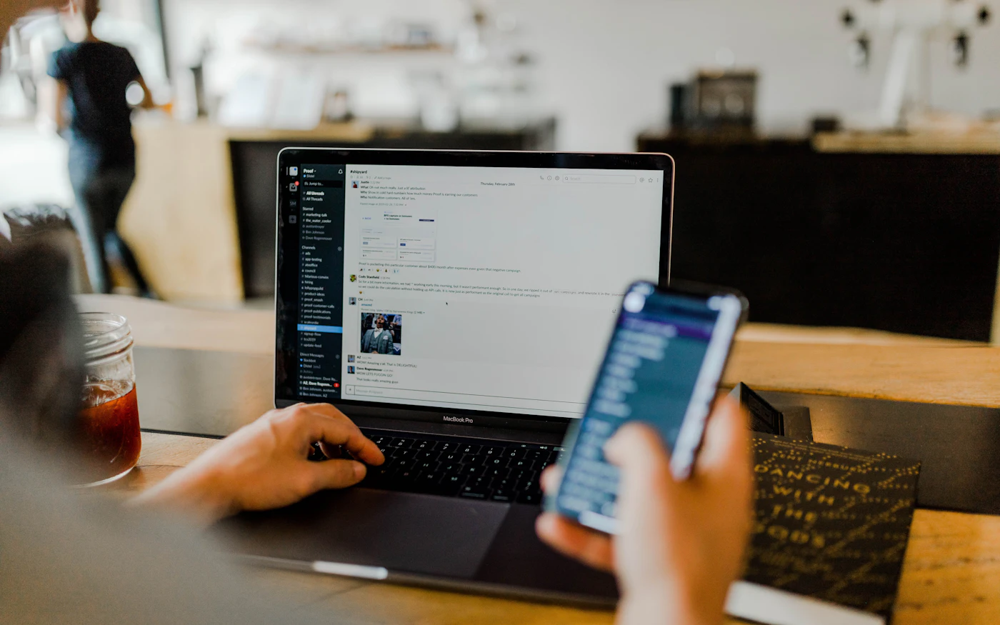 Laptop and smartphone being used together at a café table