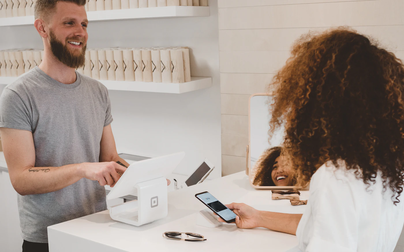 Customer paying with a smartphone at a shop counter