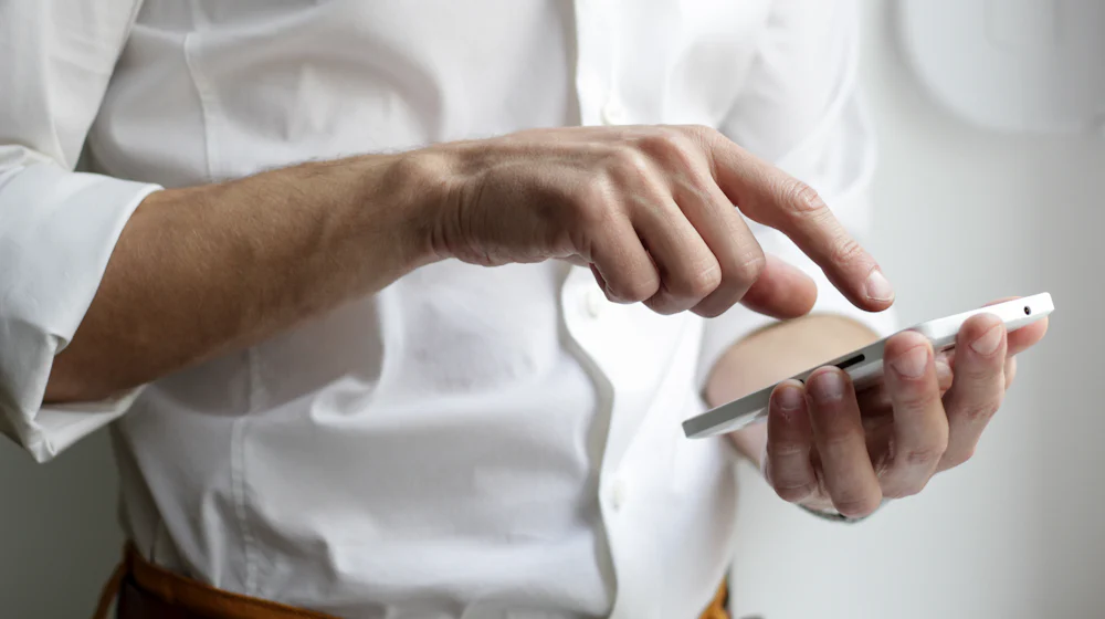 Hand holding a smartphone while checking mobile settings