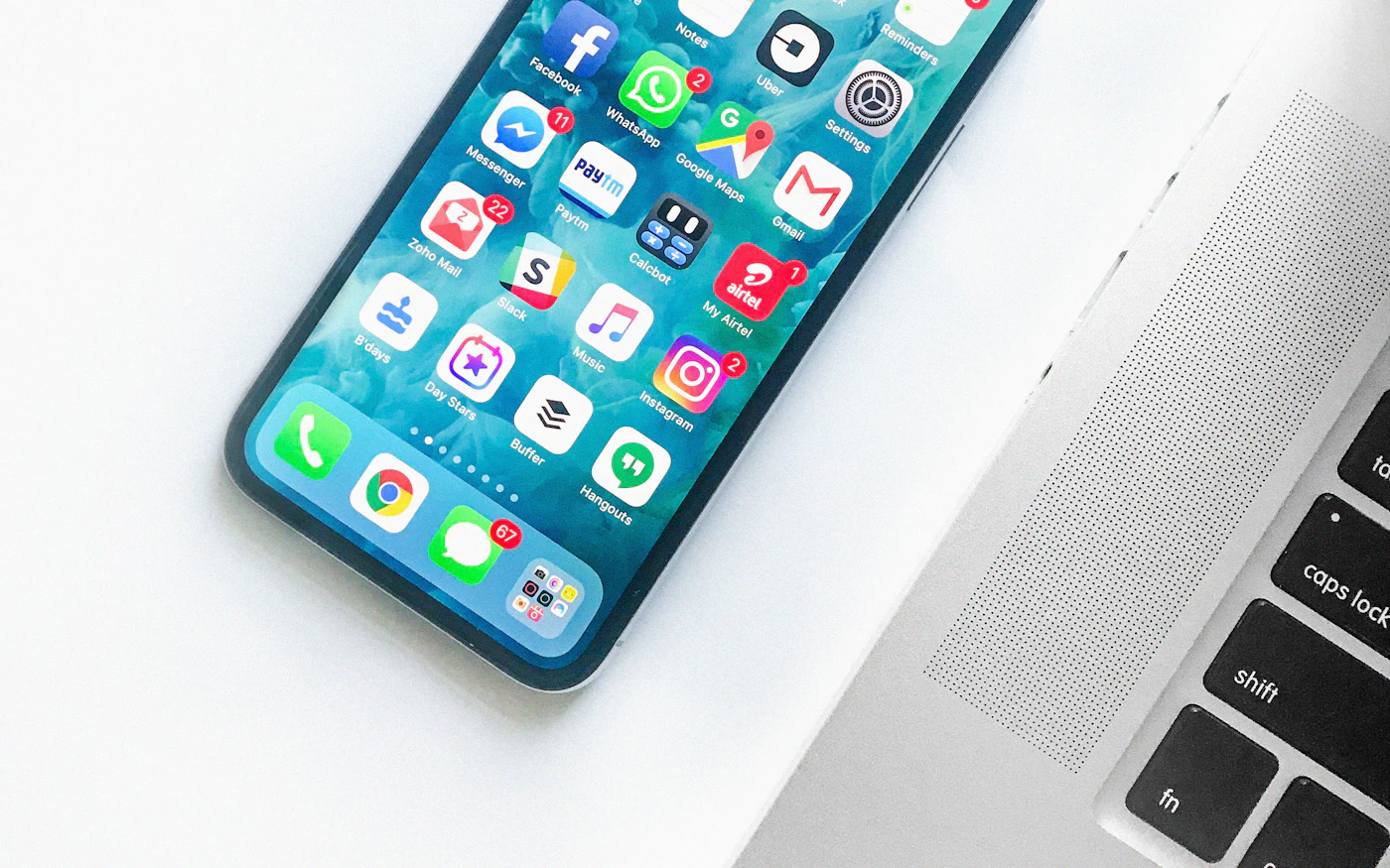 Smartphone lying on a desk next to a laptop