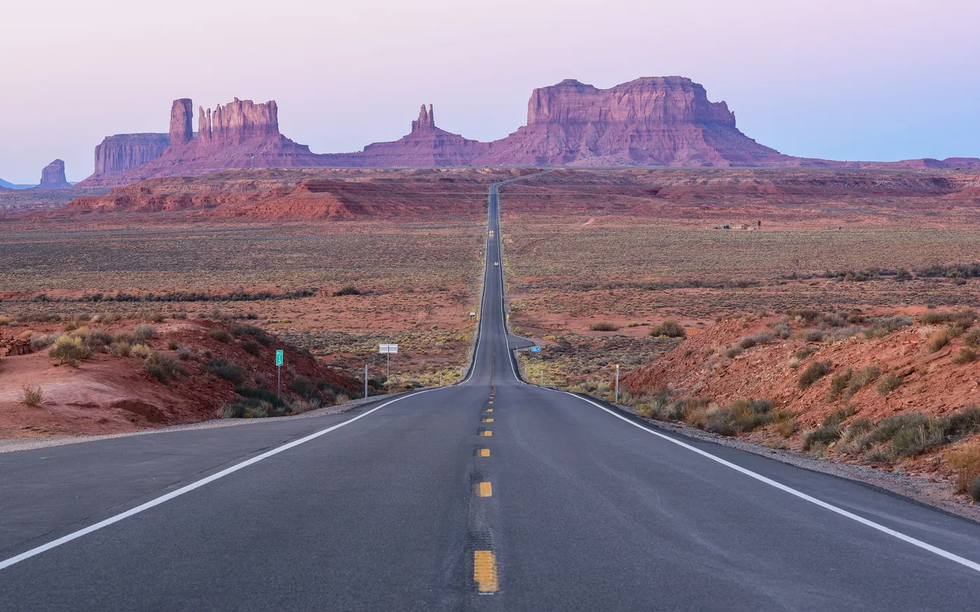 A straight highway leading toward the buttes of Monument Valley