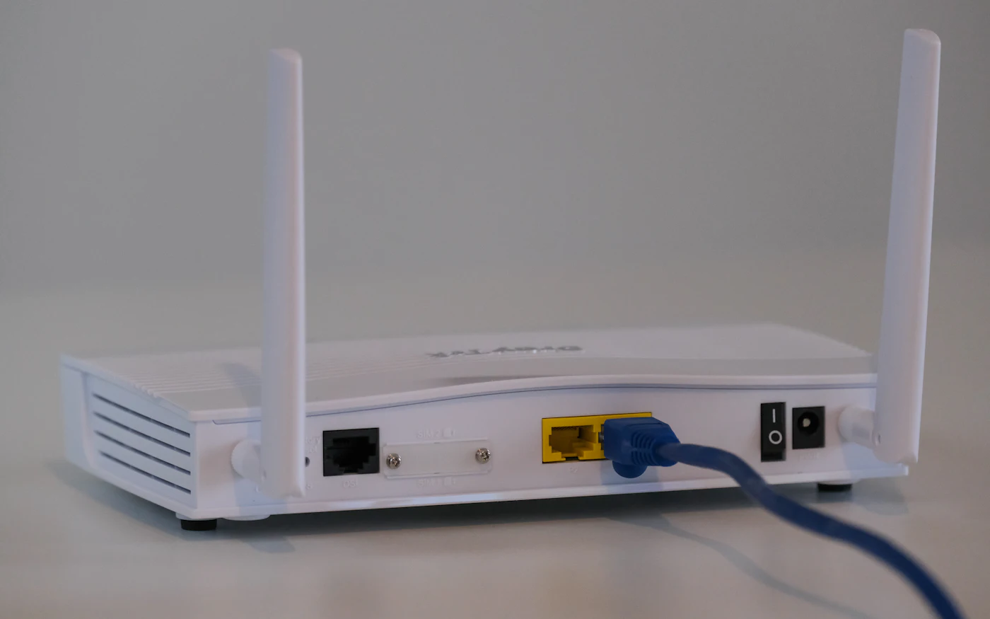 Wireless router with antennas and a network cable plugged in