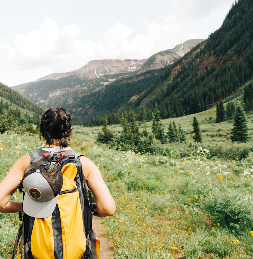 Backpacker hiking through a green mountain valley abroad