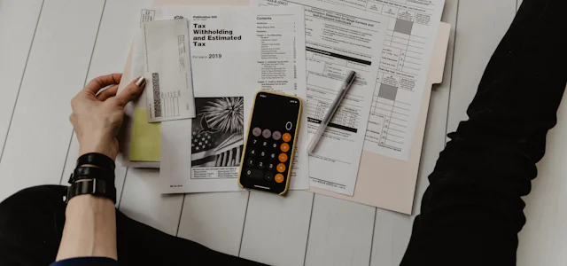 Person checking bills with a calculator and phone