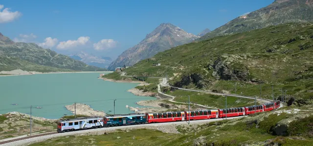 Bernina Express train beside a lake in the Swiss Alps