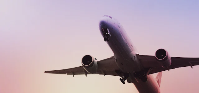 Airplane taking off at sunset
